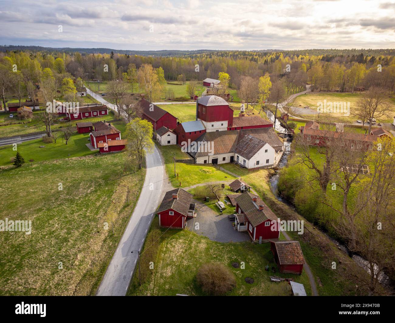 Vista aerea di un villaggio di campagna con case rosse, circondato dal verde, che mostra il fascino rurale. Foto Stock