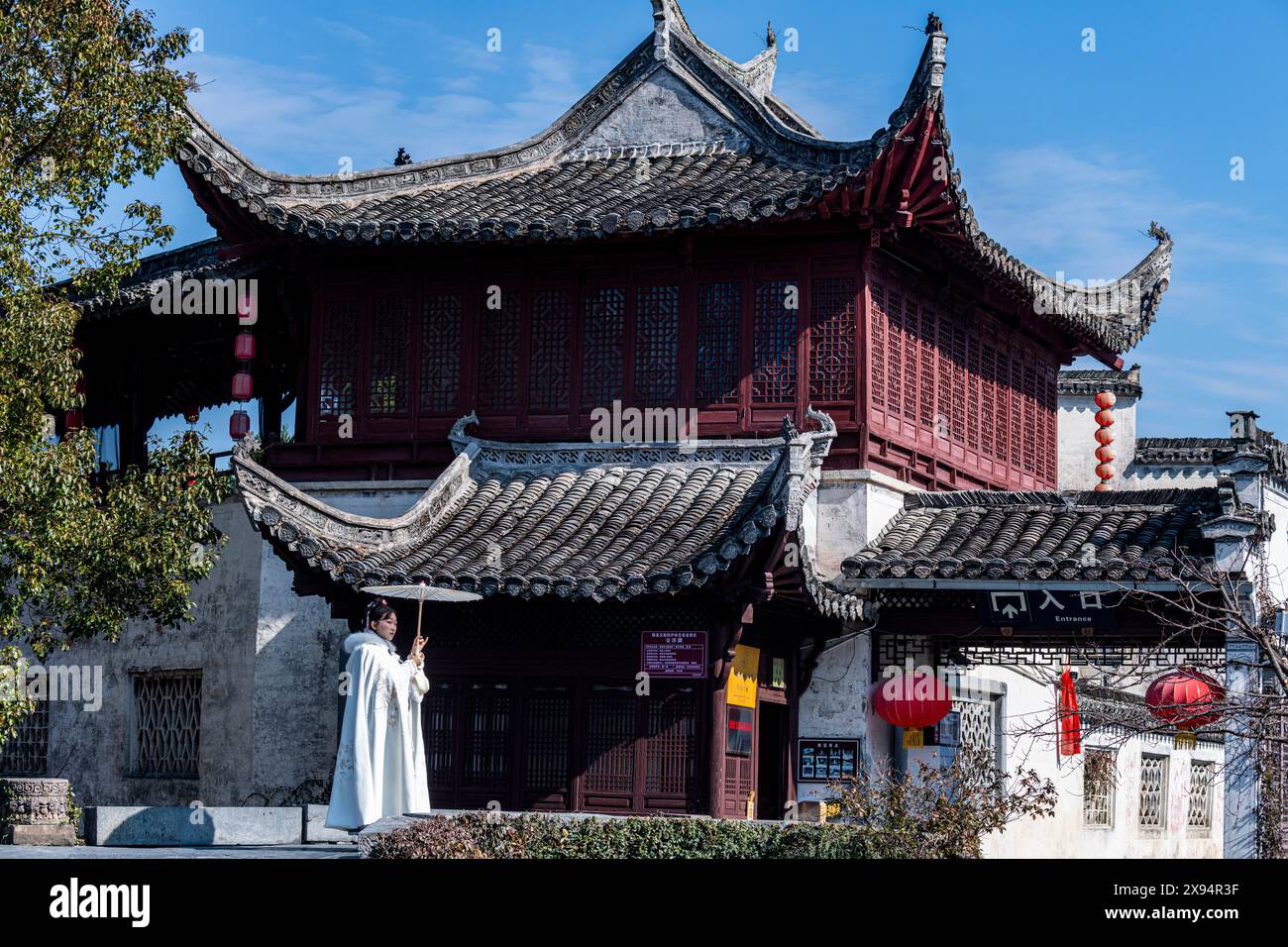 Donna che posa di fronte a una vecchia casa, villaggio storico di Xidi, sito patrimonio dell'umanità dell'UNESCO, Anhui, Cina, Asia Foto Stock
