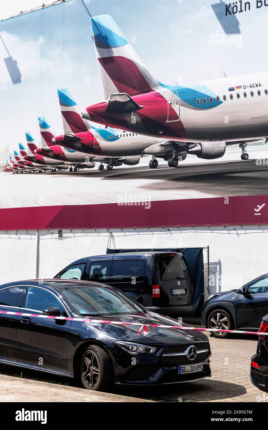 Auto parcheggiate di fronte a un grande cartellone aereo nel quartiere Muelheim di Colonia, in Germania. Geparkte Autos vor einem grossen Werbeplakat einer flu Foto Stock