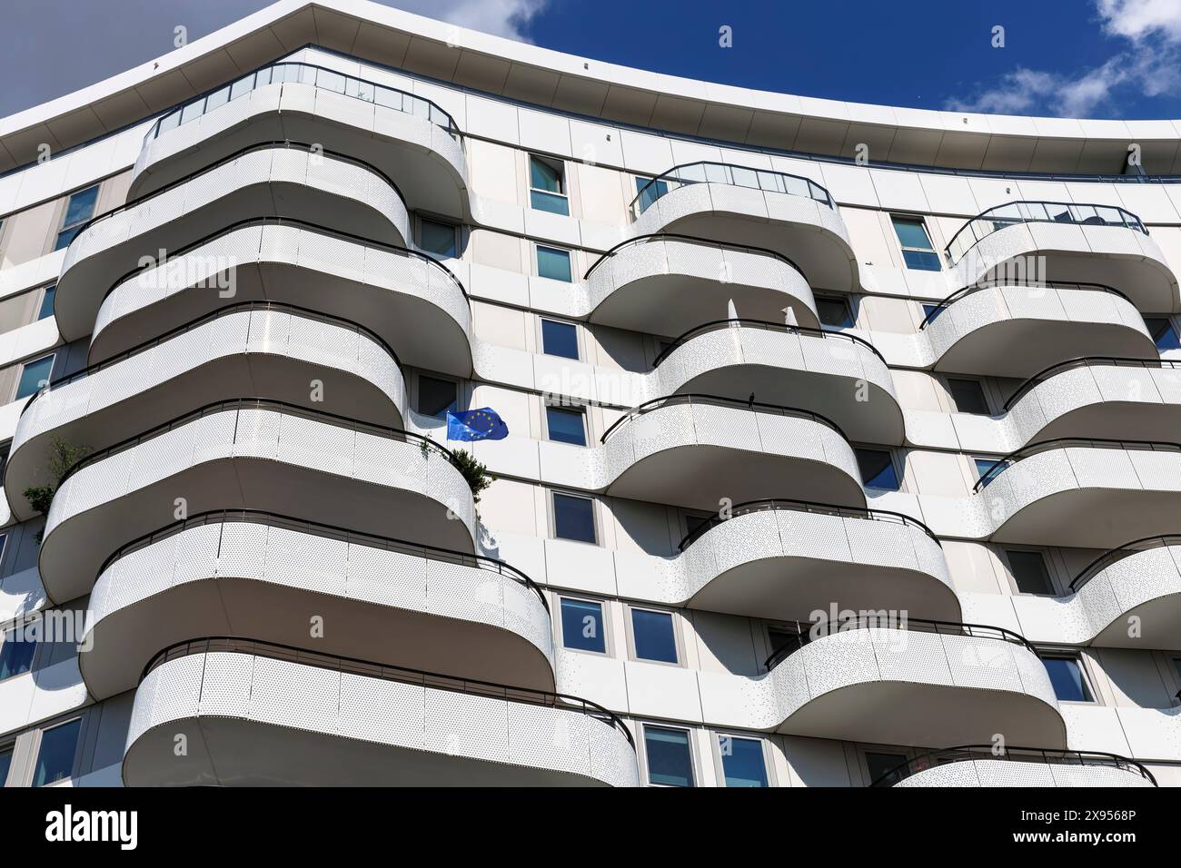 Balconi dell'edificio di appartamenti Flow Tower nel quartiere Bayenthal, bandiera europea, Colonia, Germania. Balkone des Flow Tower im Stadtteil Bayenth Foto Stock
