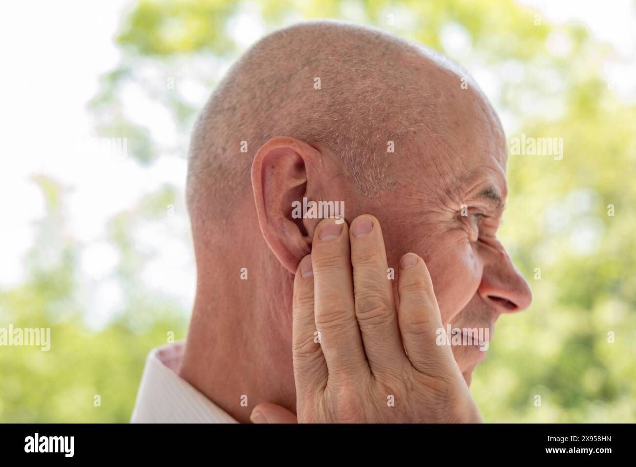 l'uomo maturo tiene l'orecchio doloroso, perdita dell'udito, primo piano del viso, concetto medico, controllo dell'udito, infiammazione dell'orecchio medio, otite media Foto Stock