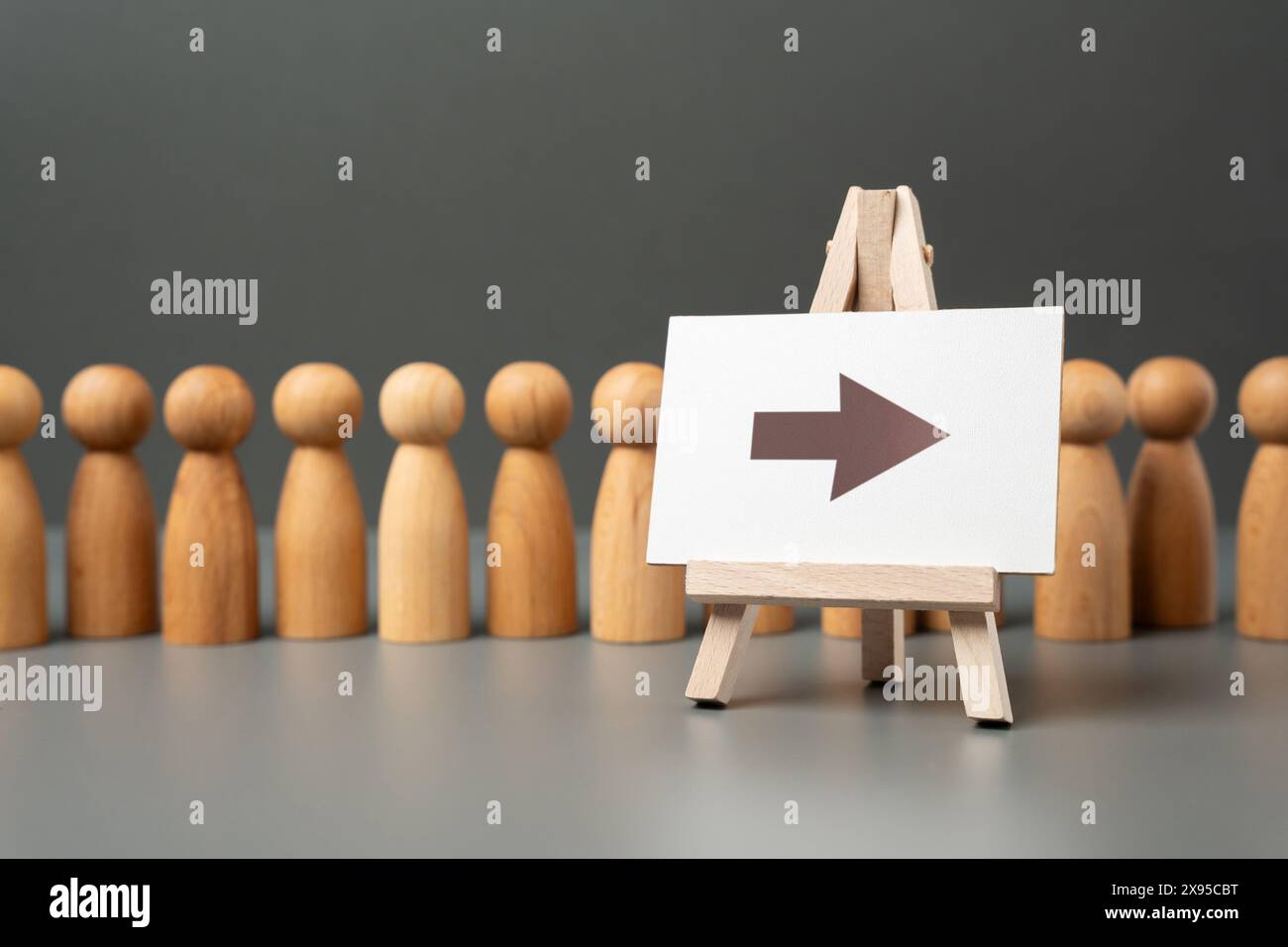 Una linea di persone e una freccia su un cartello. Coda. Riunione pubblica e folla di persone. Foto Stock