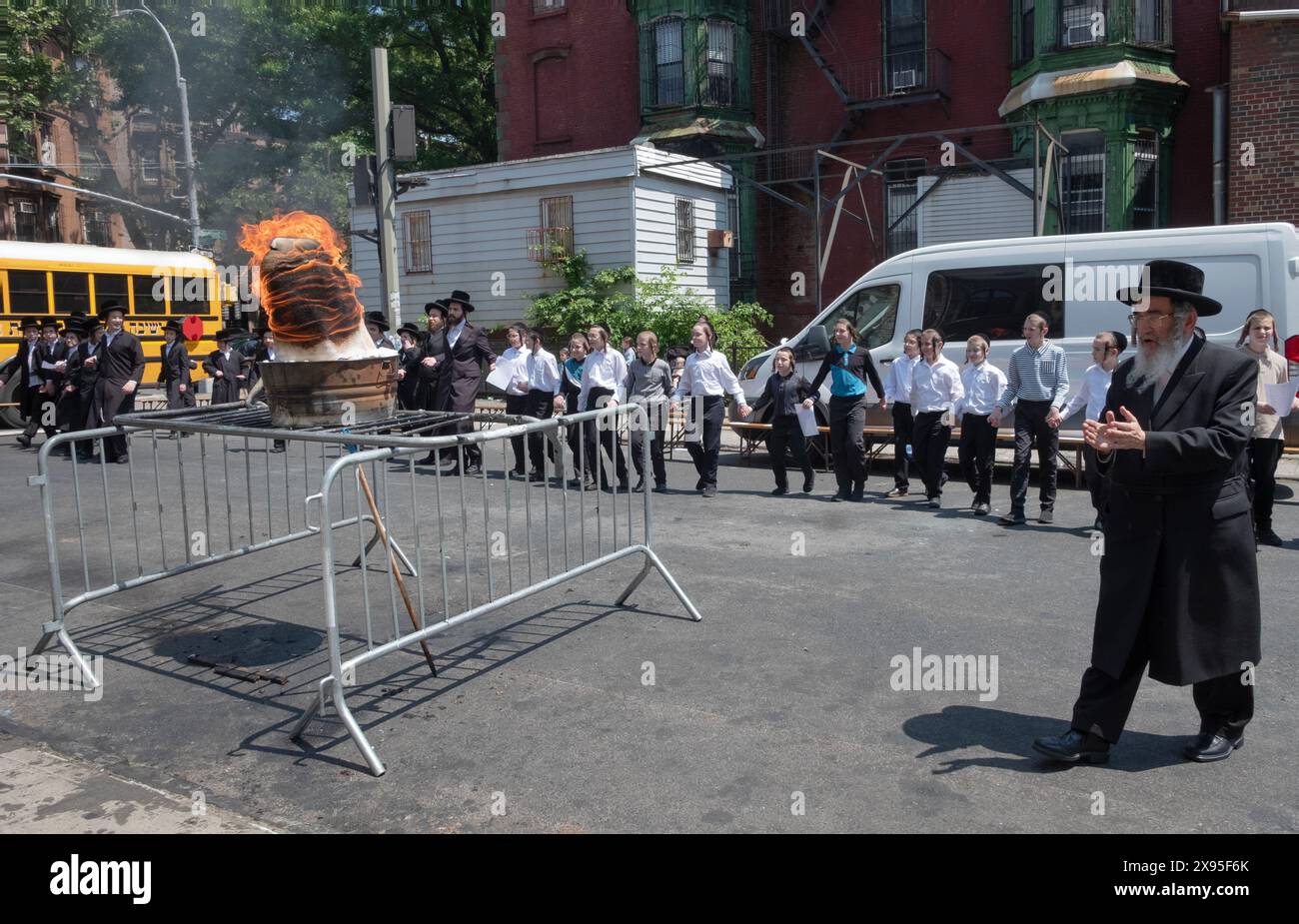 Rabbini e studenti di una yeshiva di New York celebrano il LAG B'Omer in una cerimonia divertente con un fuoco tradizionale. A Brooklyn, New York. Foto Stock