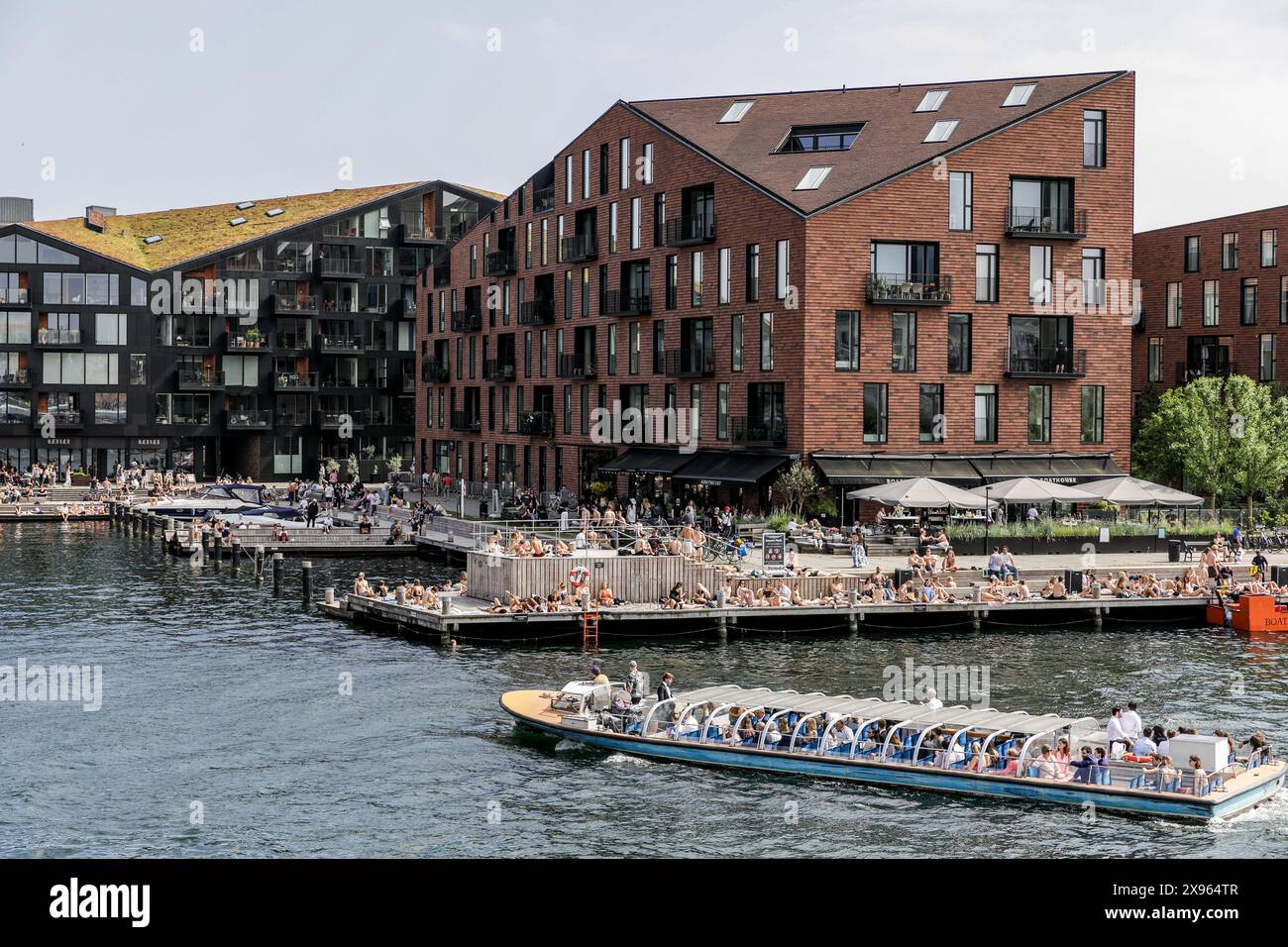 Copenaghen, Danimarca. 25 maggio 2024. Le persone si godono un caldo sabato pomeriggio sul lungomare nel centro di Copenaghen. Copenhagen si posiziona al quarto posto al mondo nel sondaggio sulla qualità della vita Mercer 2023. Un'economia stabile, eccellenti servizi educativi e un'elevata sicurezza sociale lo rendono attraente per la gente del posto e per i turisti. Copenaghen è anche una delle città più costose del mondo e una popolare destinazione turistica. (Foto di Volha Shukaila/SOPA Images/Sipa USA) credito: SIPA USA/Alamy Live News Foto Stock