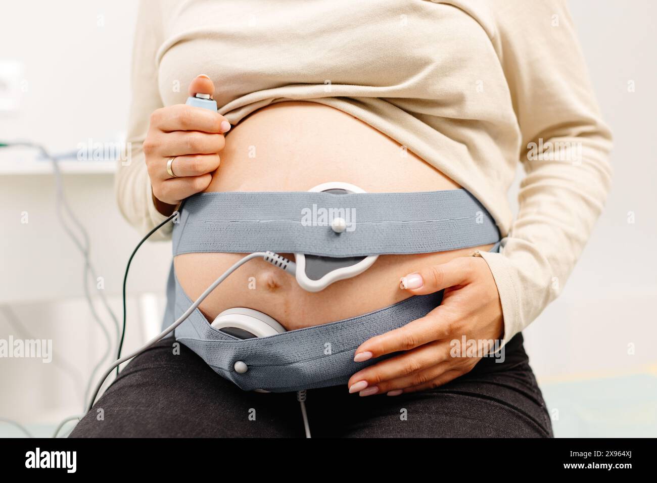 Donna incinta controllo del battito cardiaco fetale mediante monitoraggio fetale. Donna in attesa con ostetrica che regola i sensori fuori dalla cardiotocografia (CTG). Foto Stock