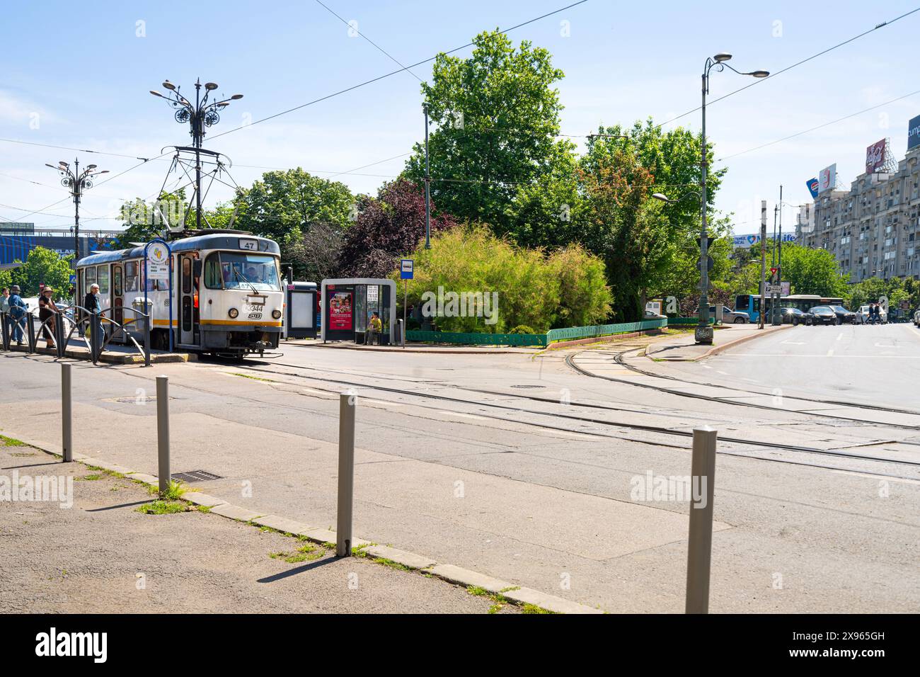 Bucarest, Romania. 24 maggio 2024. persone alla fermata del tram in una piazza del centro città Foto Stock