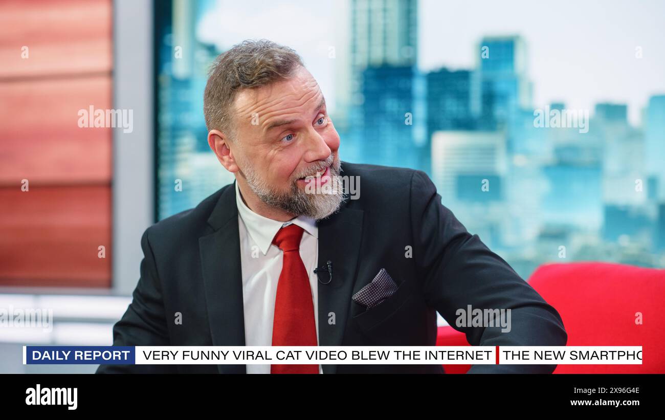 Talk Show TV Program, News Discussion: Cheerful White male Presenter Talks, ascolta gli ospiti. L'host o l'ospite del canale via cavo hanno una conversazione. Studio televisivo mockup e concetto di intrattenimento Foto Stock