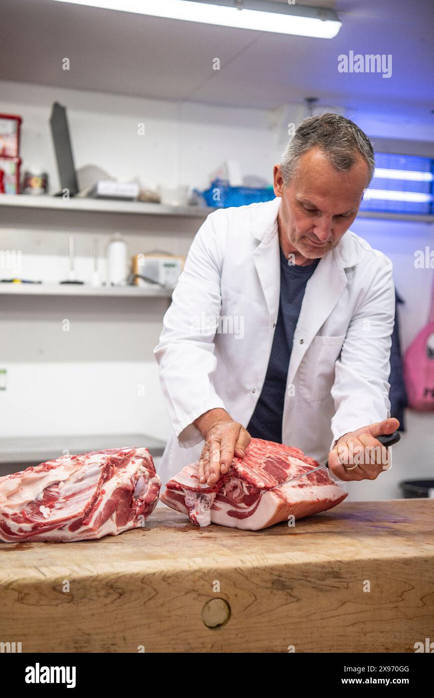 Butcher il taglio di carne di maiale Foto Stock