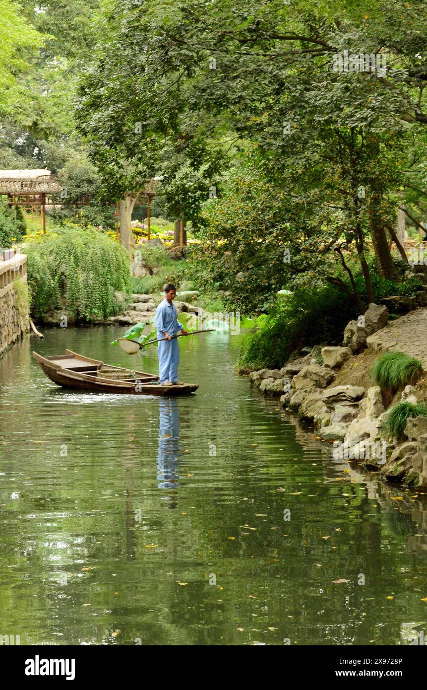 Barcaiolo e riflesso sul lago nel giardino dell'amministratore dell'umile giardino dell'amministratore, Suzhou, Jiangsu, Cina Foto Stock
