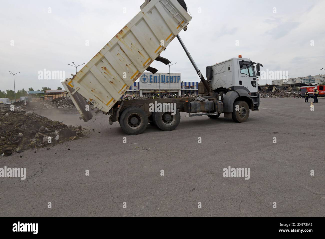 Charkiv, Ucraina, 29 maggio 2024. Un camion ribaltabile accumula detriti dall'interno del negozio K dell'epicentro distrutto mentre i vigili del fuoco e i soccorritori continuano a cercare i detriti dopo che le bombe guidate russe UMPB D30-SN hanno colpito il negozio sabato. Un uomo di 40 anni è morto oggi in ospedale dopo aver subito gravi ustioni durante l'attacco, portando il bilancio delle vittime a 19. G P Essex/Alamy Live News Foto Stock