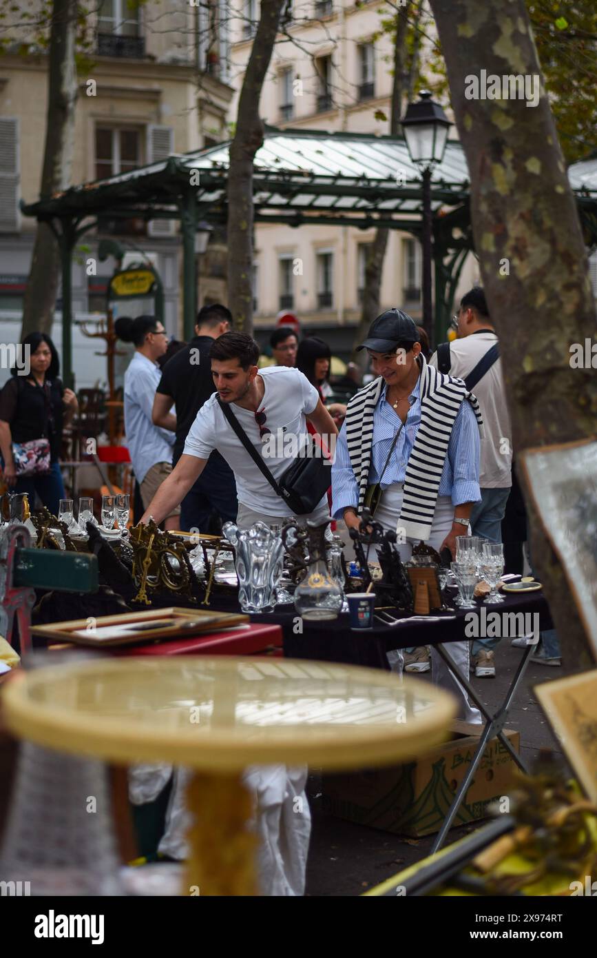 Parigi, Francia coppia non identificata che guarda l'antiquariato in un mercato delle pulci a Abbesses, Parigi. Foto Stock
