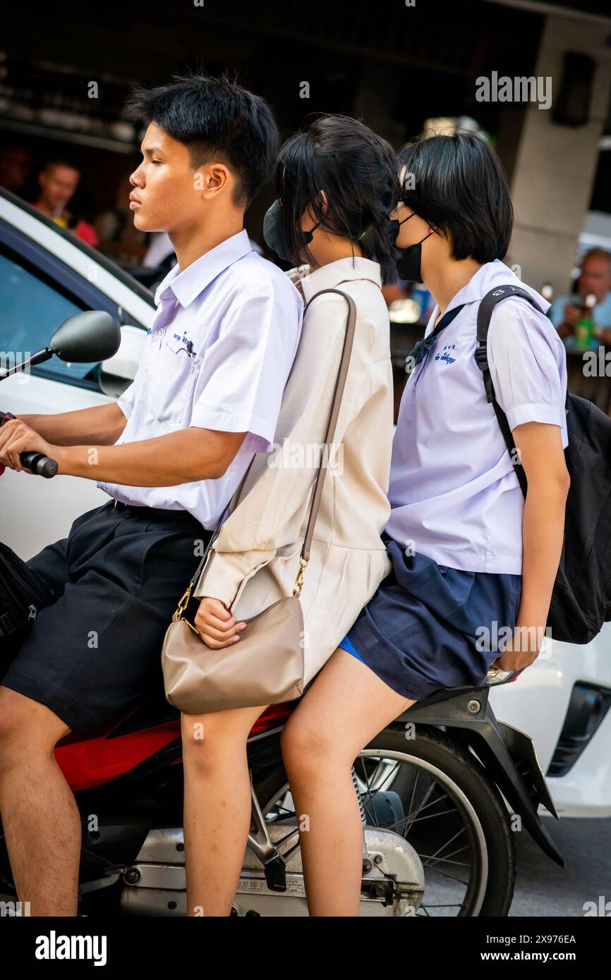 Tre ragazzi thailandesi si dirigono a casa su uno scooter a Pattaya in Thailandia. Viaggiando lungo Soi Buakhao nel centro di Pattaya. Foto Stock