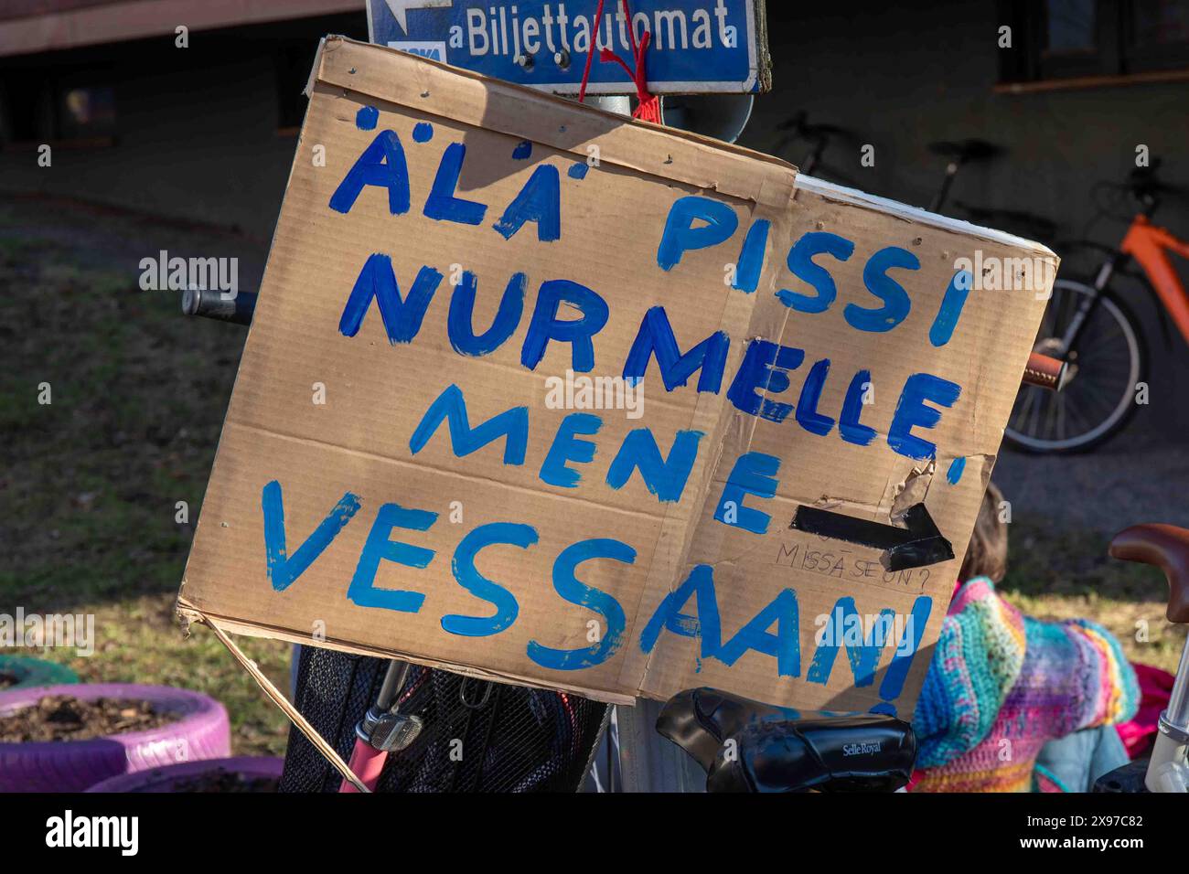 Älä pissi nurmelle, mene vessaan! Cartello con l'indicazione vicino ad Hartolanpuisto durante il ballo della vigilia di maggio nel quartiere Vallila di Helsinki, Finlandia. Foto Stock