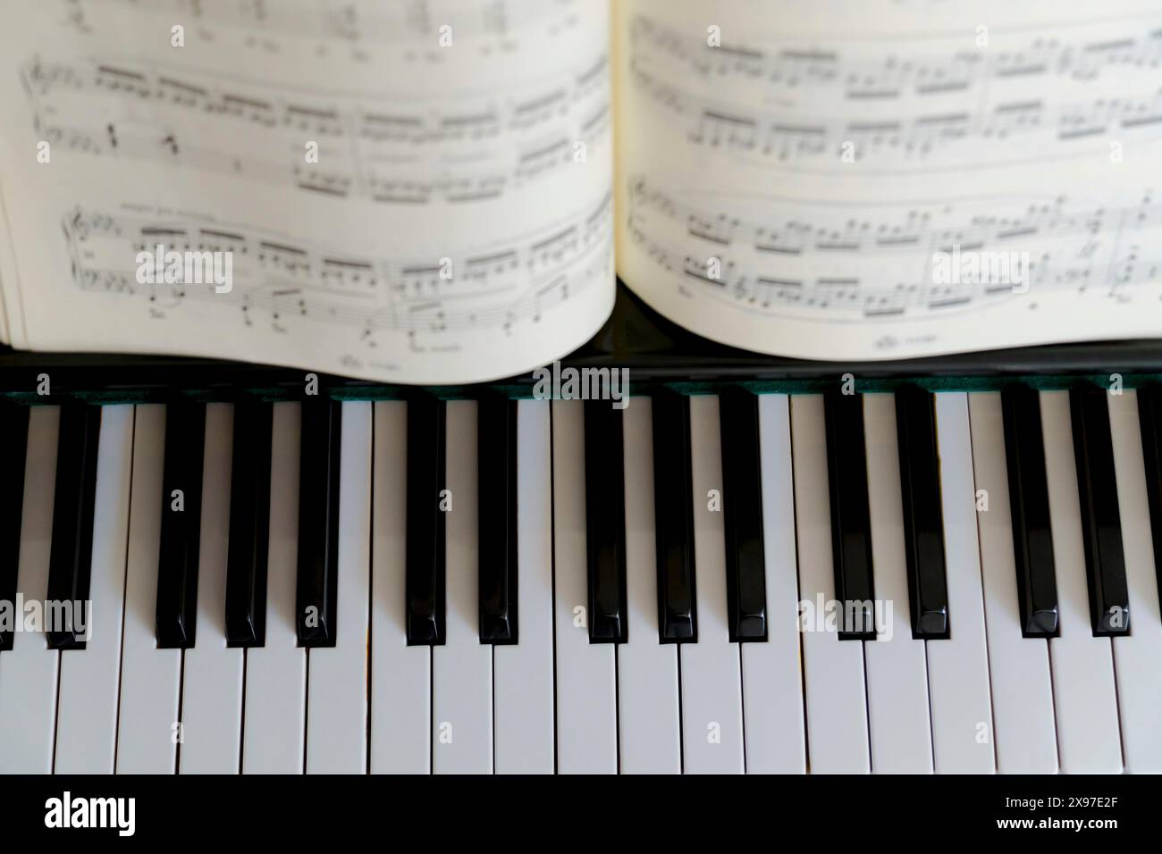 Vista dall'alto dei tasti di un pianoforte con una partitura Foto Stock