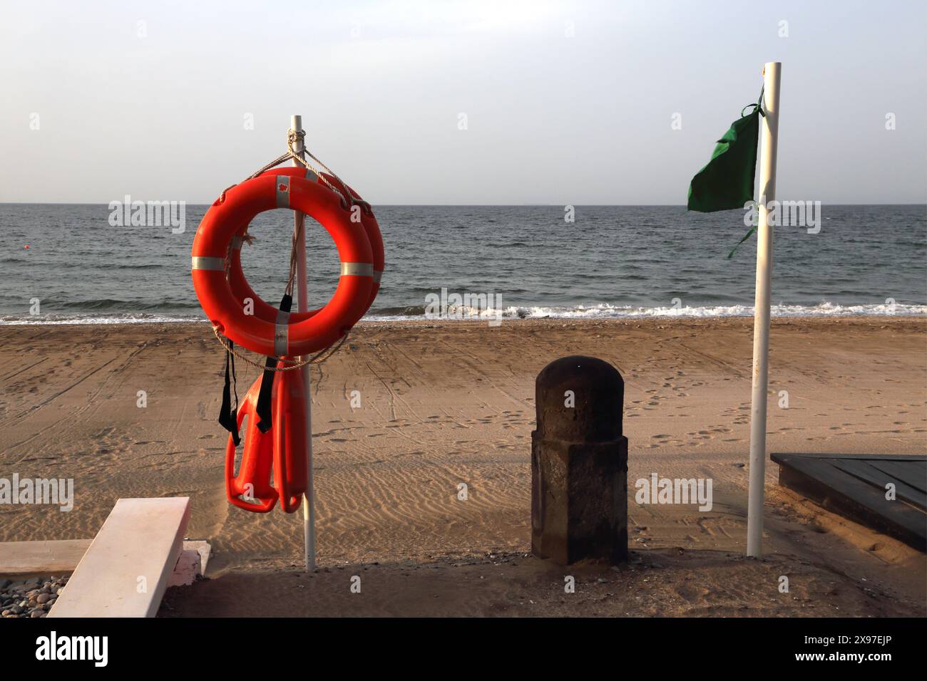 Lifebuoy Ring e galleggianti all'ingresso del Chedi Hotel Beach con bandiera verde Muscat Oman Foto Stock