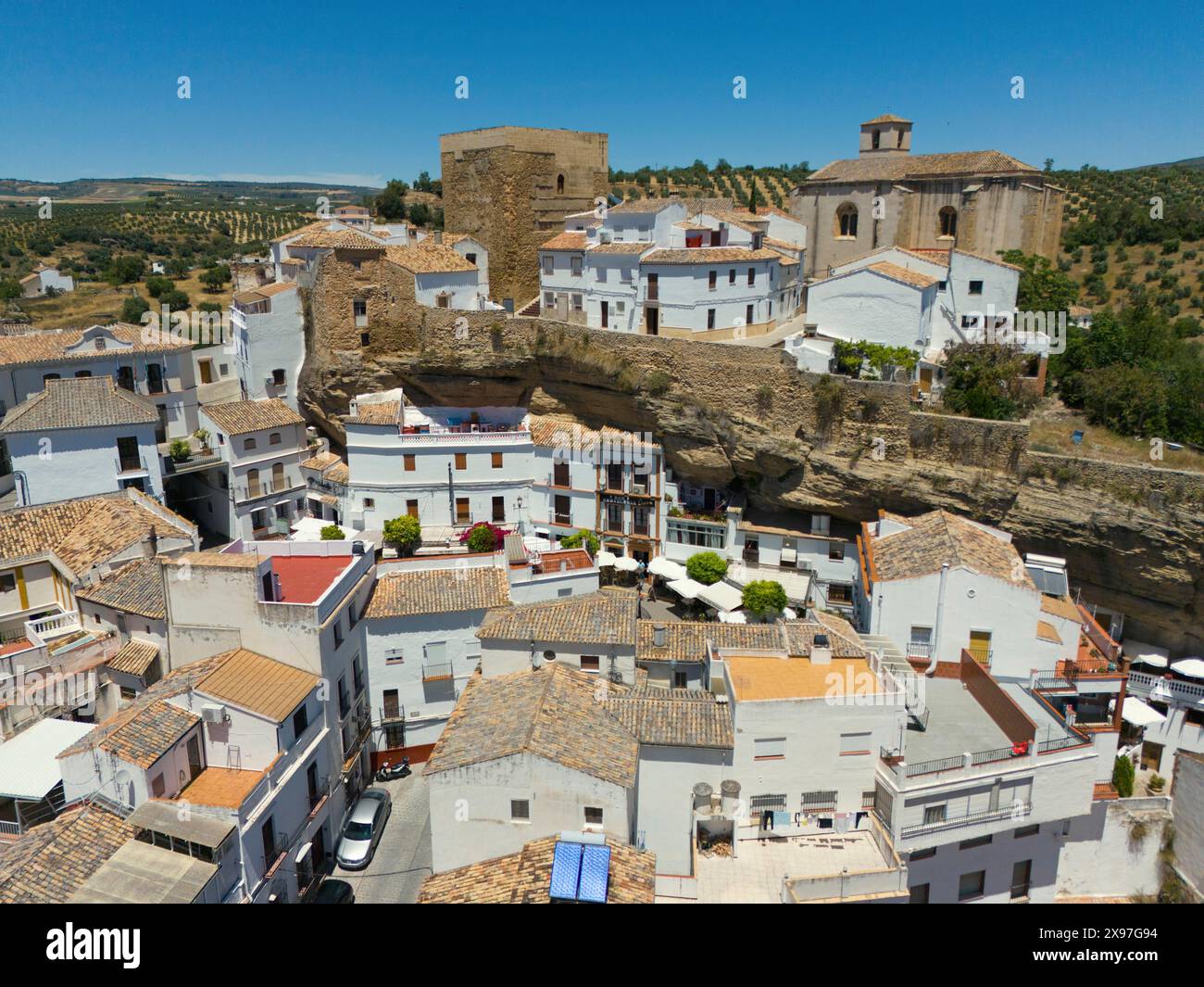 Vista aerea di un villaggio spagnolo con edifici bianchi, edifici storici, chiese e oliveti in un paesaggio mediterraneo, vista aerea, grotta Foto Stock
