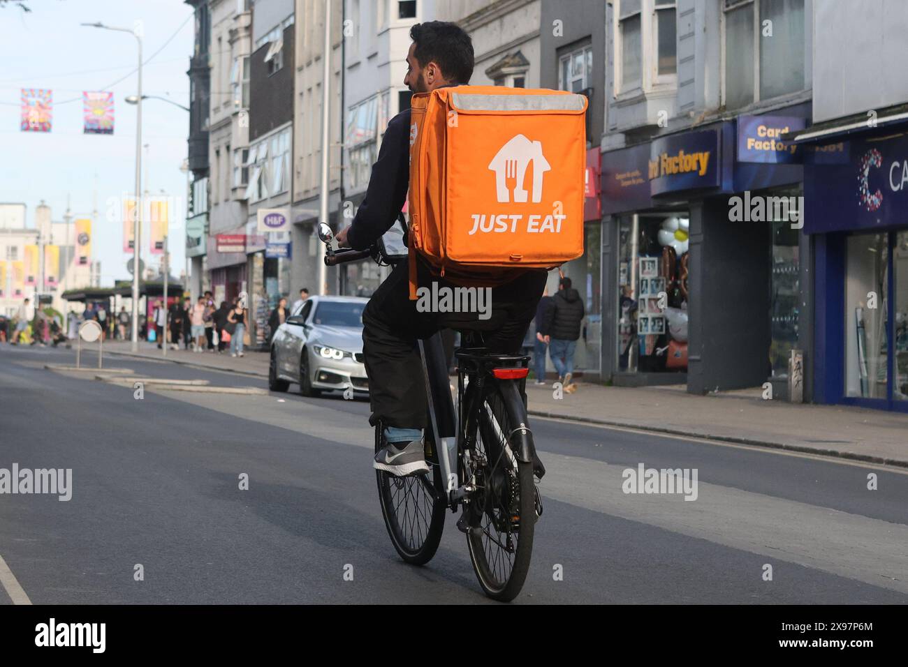 Basta mangiare un corriere in bicicletta a Brighton Foto Stock