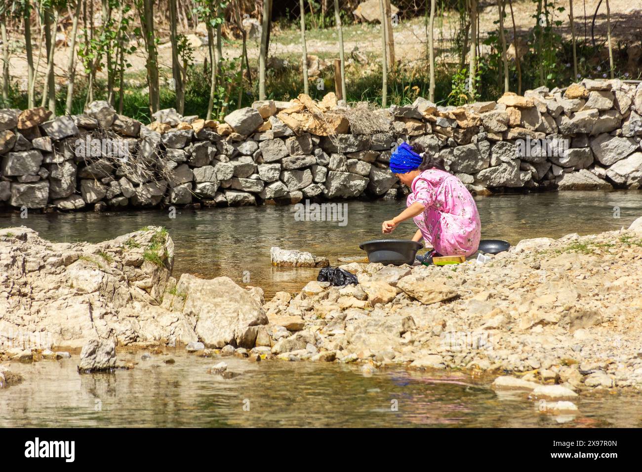 Haft Kul, Tagikistan, 21 agosto 2023: Lavatrice di piatti nel fiume nelle montagne fan Foto Stock