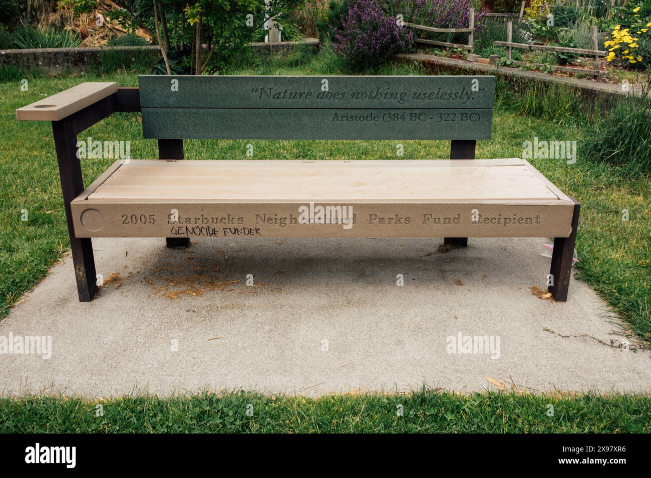 Panchina pubblica nel parco Oxbow a Georgetown con citazione di Aristotele sulla natura, Starbucks Parks finanziano la dedizione dei beneficiari, graffiti per genocidio Foto Stock