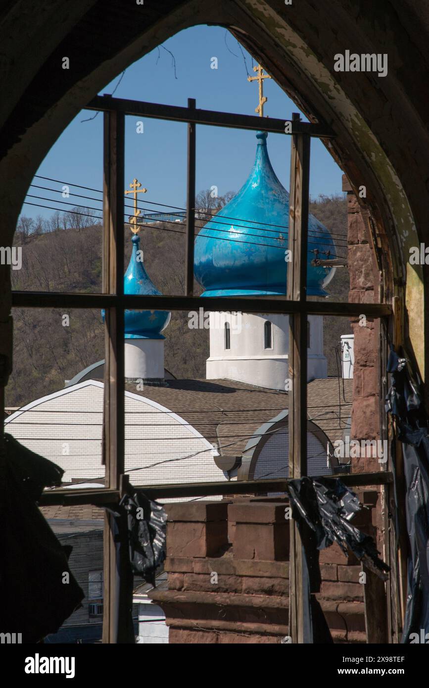 Vista della cupola della cipolla della Chiesa cattolica ortodossa russa di Santa Maria, vista attraverso un'altra finestra abbandonata della chiesa. Foto Stock