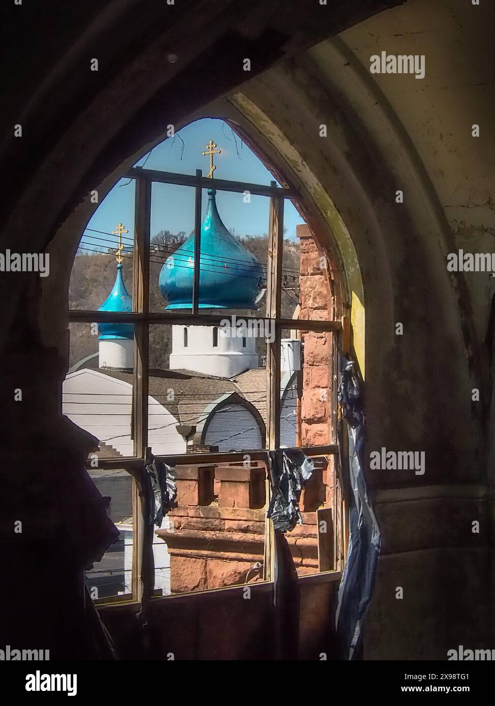 Vista della cupola della cipolla della Chiesa cattolica ortodossa russa di Santa Maria, vista attraverso un'altra finestra abbandonata della chiesa. Foto Stock