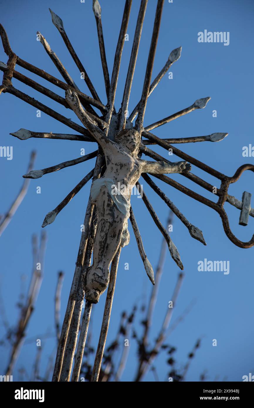 Vecchia croce di metallo con un crocifisso su uno sfondo cielo senza nuvole. Immagine verticale. Foto Stock