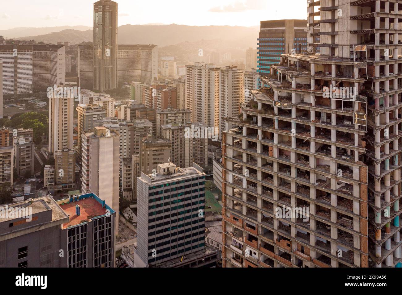 Vista aerea di Caracas al tramonto con il grattacielo e le baraccopoli simbolo della David Tower visibili. Un drone della capitale venezuelana al tramonto. Concetto o Foto Stock