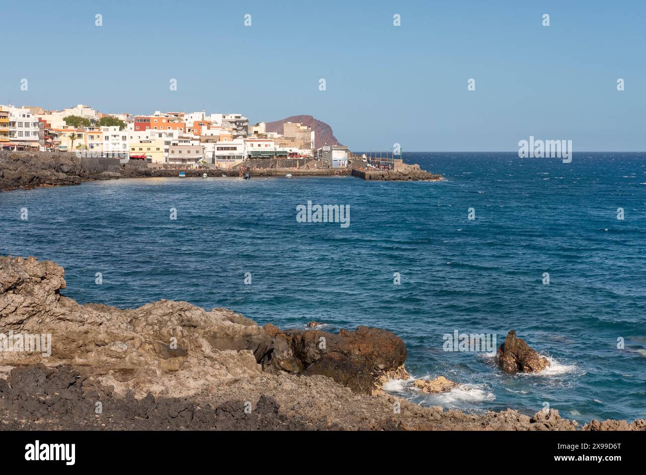 Viste dell'aspra costa vulcanica e dell'Oceano Atlantico blu profondo e dell'affascinante villaggio di pescatori di Los Abrigos con i suoi edifici colorati, Tenerife Foto Stock