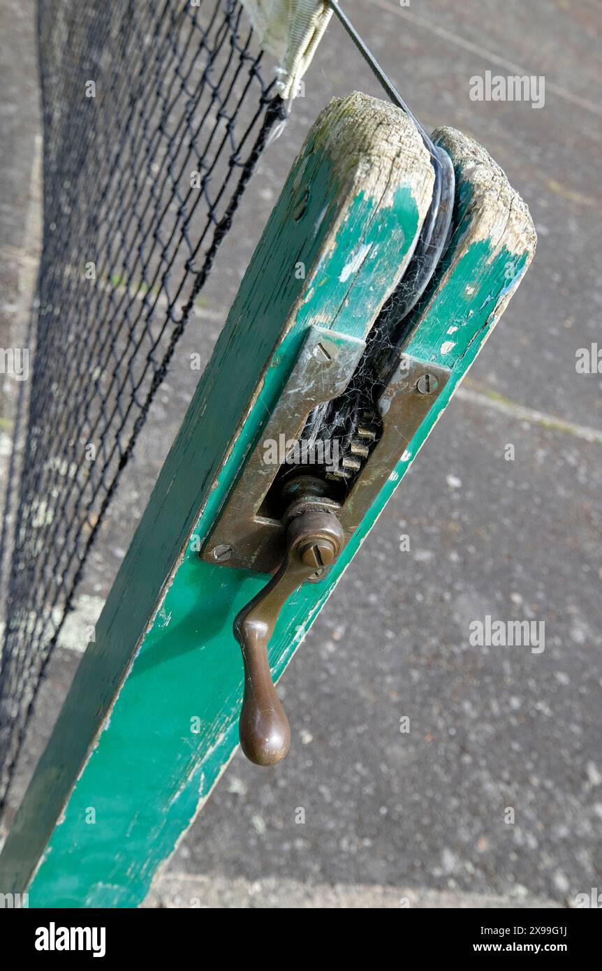 vecchio manico per avvolgere la rete da tennis sulla superficie del campo duro, devon, inghilterra Foto Stock