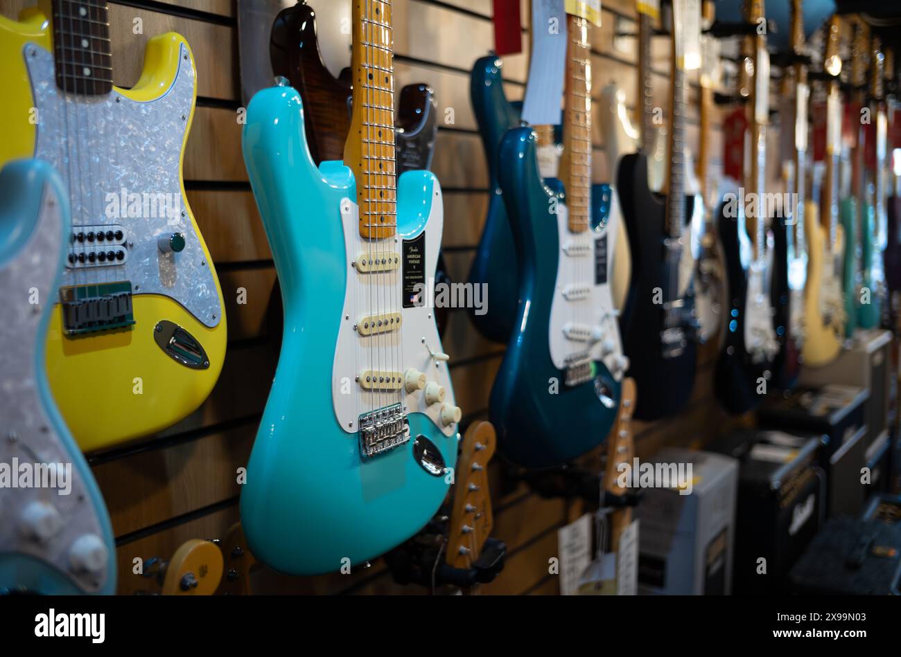 Una chitarra elettrica Fender American Vintage II turchese appesa ad altre chitarre elettriche in vendita al Gak Music Emprorium di Brighton, East Sussex, U Foto Stock