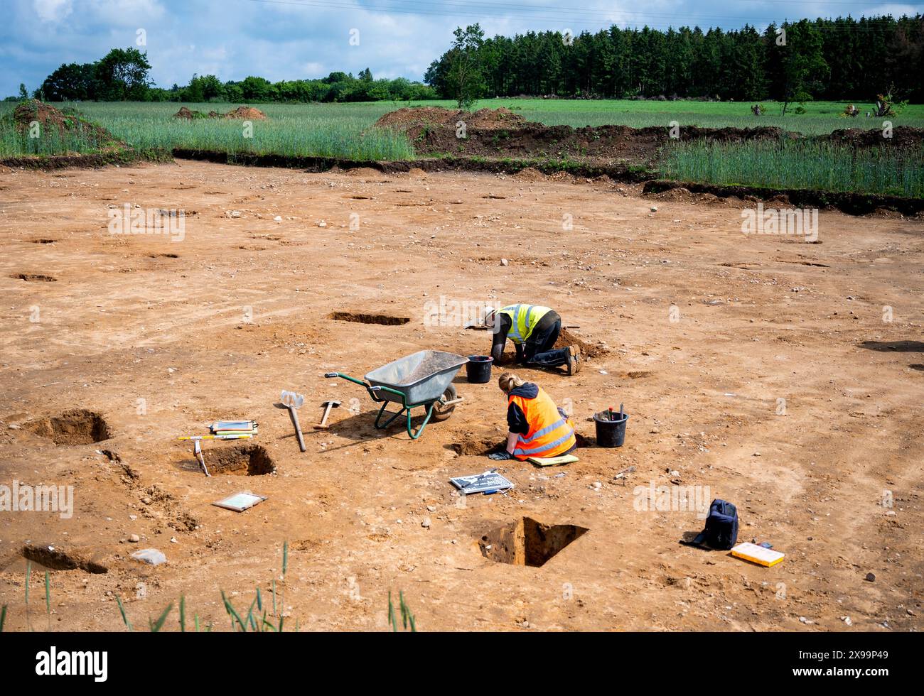 Hohenwestedt, Germania. 30 maggio 2024. I lavoratori degli scavi realizzano tagli di profilo dei pozzi di pali in un cantiere edile. Durante gli scavi, l'Ufficio Archeologico di Stato ha realizzato reperti di insediamenti risalenti all'età del bronzo, al periodo imperiale romano e al periodo della migrazione imperiale. Credito: Daniel Bockwoldt/dpa/Alamy Live News Foto Stock