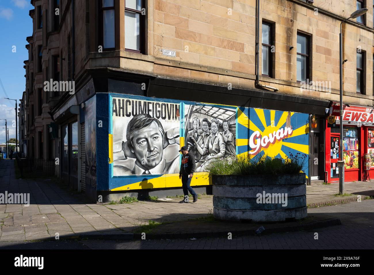 Ahcumfigovin murale di Sir Alex Ferguson e donne lavoratori delle munizioni in tempo di guerra dipinto da Frank e Mandy Carty, Uist Street, Govan, Glasgow, Scozia Foto Stock
