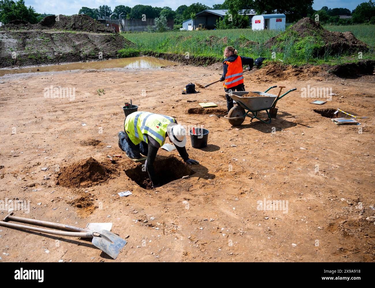 Hohenwestedt, Germania. 30 maggio 2024. I lavoratori degli scavi realizzano tagli di profilo dei pozzi di pali in un cantiere edile. Durante gli scavi, l'Ufficio Archeologico di Stato ha realizzato reperti di insediamenti risalenti all'età del bronzo, al periodo imperiale romano e al periodo della migrazione imperiale. Credito: Daniel Bockwoldt/dpa/Alamy Live News Foto Stock