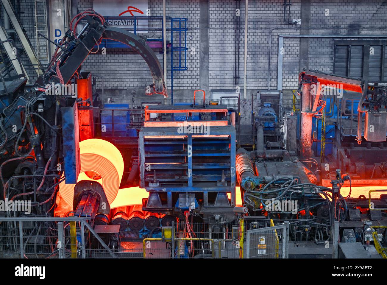 30 maggio 2024, Brandeburgo, Eisenhüttenstadt: L'acciaio piano incandescente viene avvolto in una bobina nel laminatoio a caldo di ArcelorMittal Eisenhüttenstadt GmbH. Nel pomeriggio, il ministro dell'economia federale Habeck (Verdi) dovrebbe consegnare ad ArcelorMittal una sovvenzione per la produzione di acciaio climaticamente neutrale. Il progetto congiunto di decarbonizzazione dei siti di Eisenhüttenstadt e Brema è di notevole importanza per il futuro dei due stabilimenti di acciaio piano di ArcelorMittal in Germania. Foto: Patrick Pleul/dpa Foto Stock