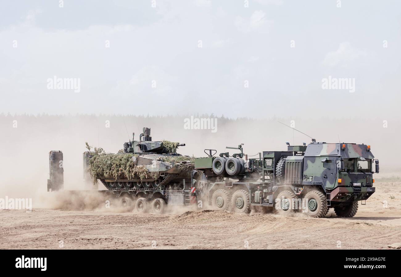 Ein Schuetzenpanzer Puma wird von einem Schwerlasttransporter Mammut abgeladen waehrend des NATO-Grossmanoevers Steadfast Defender und dem deutschen Anteil der Uebung, Quadriga 2024, in Pabrade, 29.05.2024. Pabrade Litauen *** Un vettore di personale corazzato Puma viene scaricato da un trasportatore pesante Mammut durante l'esercitazione NATO Steadfast Defender e la parte tedesca dell'esercitazione, Quadriga 2024, a Pabrade, 29 05 2024 Pabrade Lituania Copyright: xJulianexSonntagxphotothek.dex Foto Stock