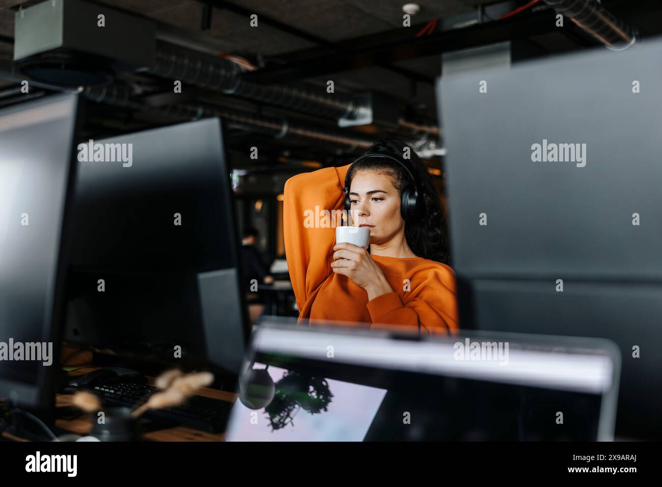 Giovane programmatrice di computer che prende un caffè durante le pause in ufficio Foto Stock