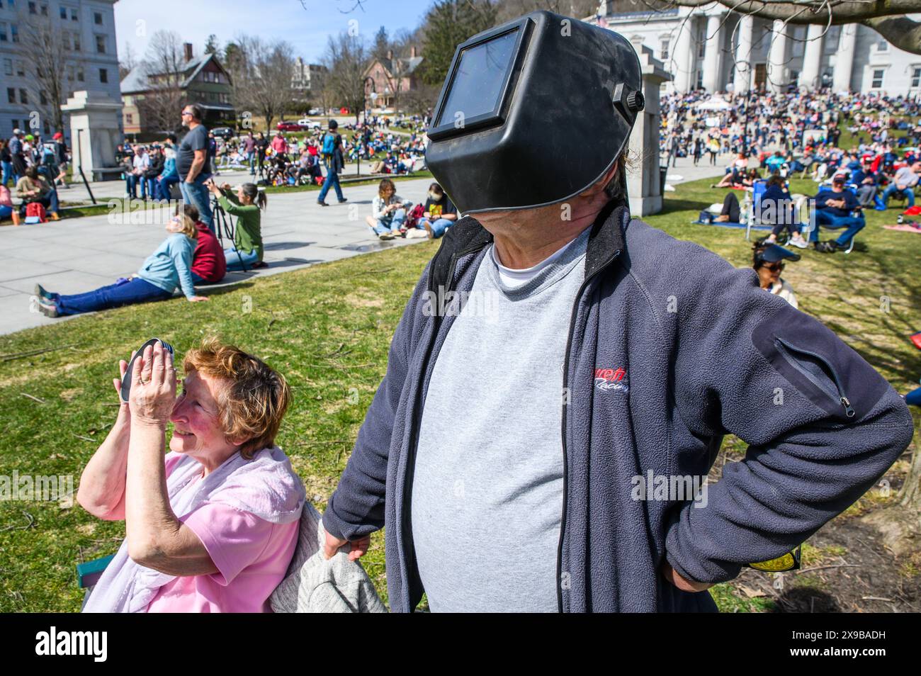 Gli spettatori guardano l'eclissi solare del 2024 dal prato del Vermont State House, Montpelier, Vermont, USA, 8 aprile, 2024. Foto Stock