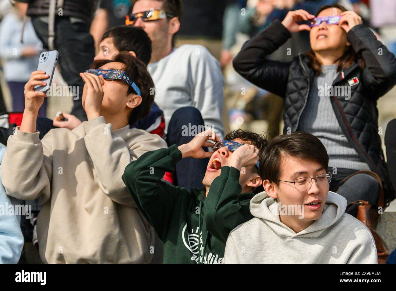 Gli spettatori guardano l'eclissi solare del 2024 dal prato del Vermont State House, Montpelier, Vermont, USA, 8 aprile, 2024. Foto Stock