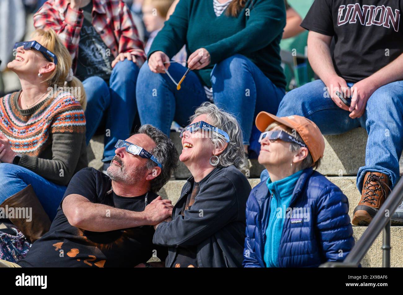 Gli spettatori guardano l'eclissi solare del 2024 dal prato del Vermont State House, Montpelier, Vermont, USA, 8 aprile, 2024. Foto Stock
