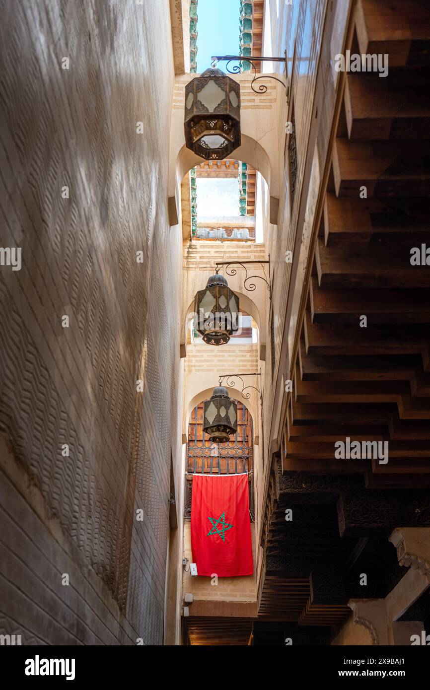 Strada stretta con bandiera marocchina, vista verso l'alto a Fez Medina, Marocco Foto Stock
