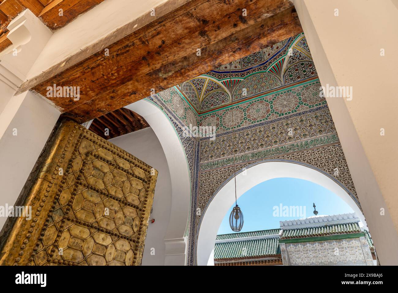 Porta d'oro e motivi geometrici islamici all'ingresso della Madrassa al Attarine a Fez, Marocco Foto Stock