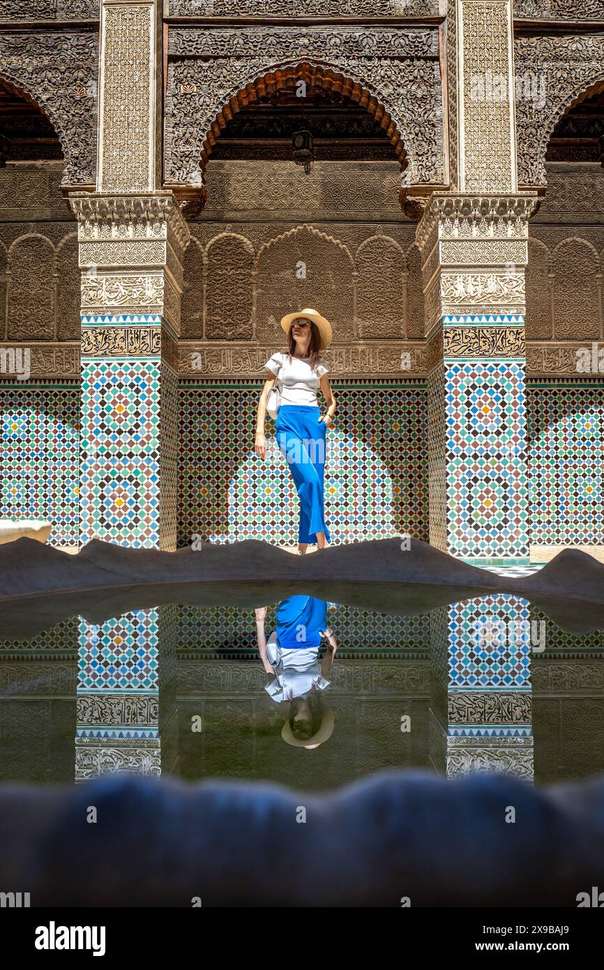 Giovane donna nella Madrassa al Attarine, elegante visitatrice nel sito storico di Fez, Marocco Foto Stock