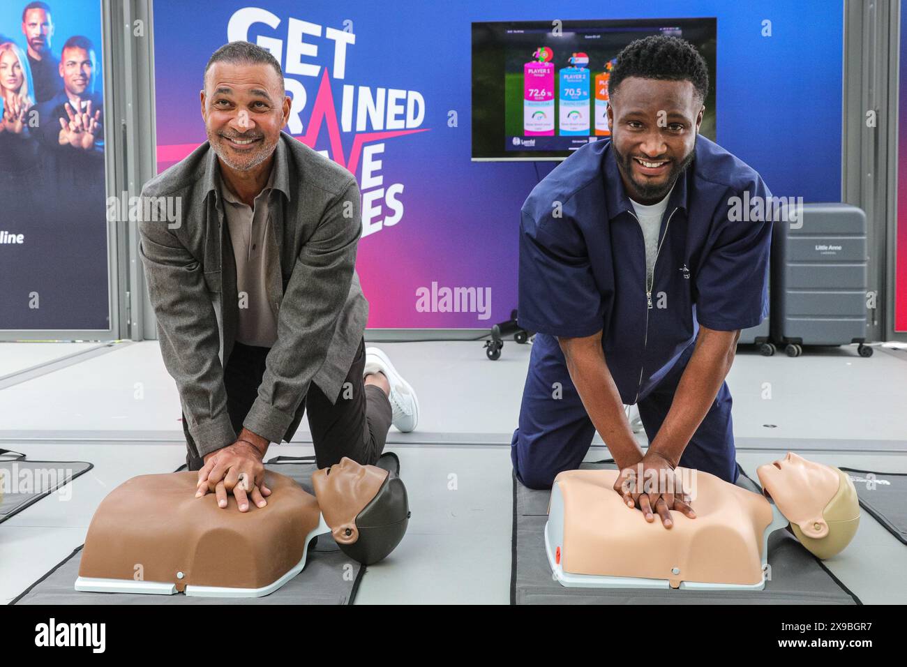 Londra, Regno Unito. 30 maggio 2024. La leggenda del calcio olandese Ruud Gullit e l'altro vincitore della UEFA Champions League Mikel John Obi (noto anche come John Obi Mikel) eseguono la RCP su un manichino allo stand della campagna CPR UEFA "Get Trainer, Save Lives" al Potters Fields Park, parte del UEFA Champions Festival gratuito per tifosi e visitatori. Crediti: Imageplotter/Alamy Live News Foto Stock