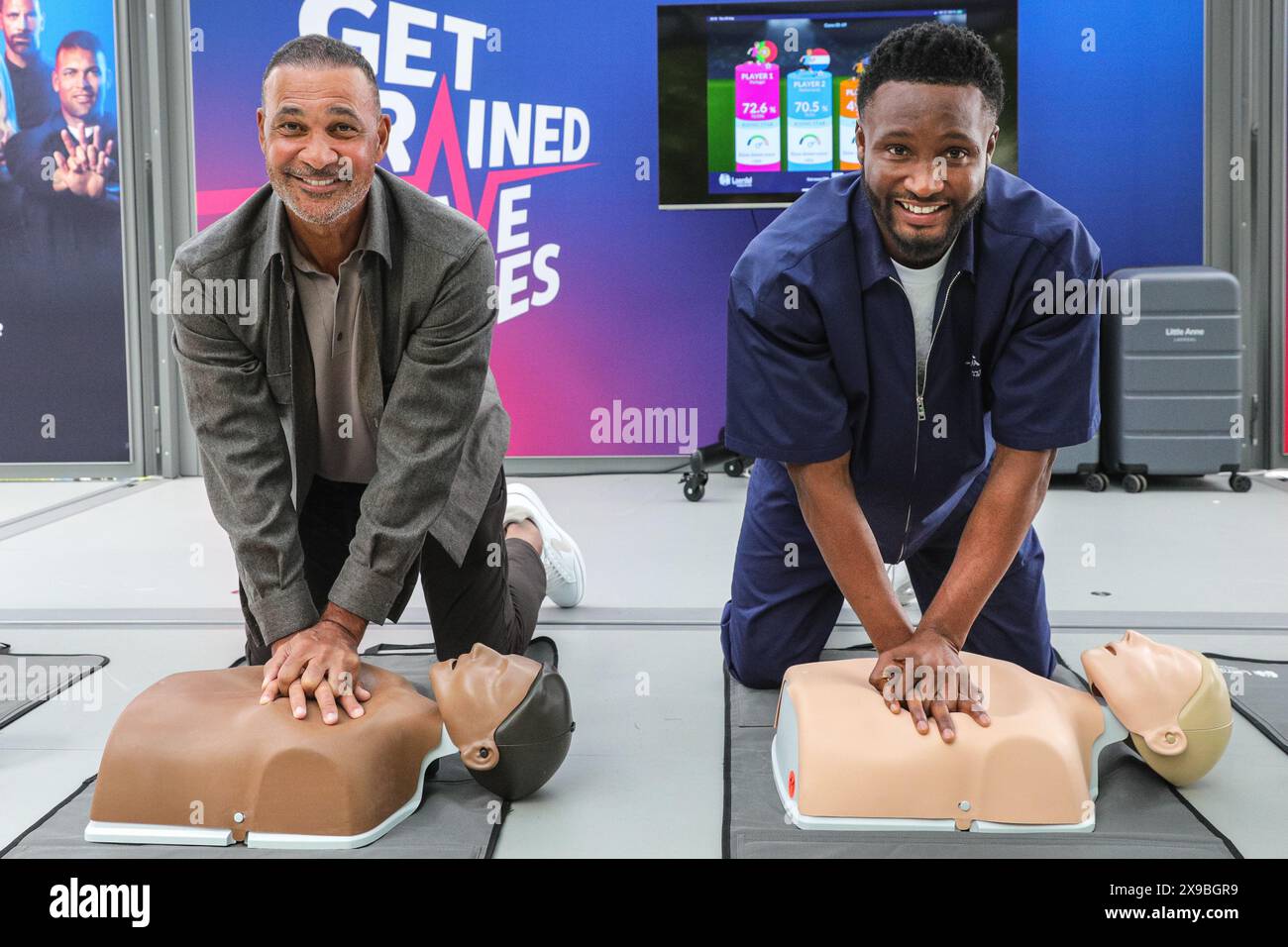 Londra, Regno Unito. 30 maggio 2024. La leggenda del calcio olandese Ruud Gullit e l'altro vincitore della UEFA Champions League Mikel John Obi (noto anche come John Obi Mikel) eseguono la RCP su un manichino allo stand della campagna CPR UEFA "Get Trainer, Save Lives" al Potters Fields Park, parte del UEFA Champions Festival gratuito per tifosi e visitatori. Crediti: Imageplotter/Alamy Live News Foto Stock