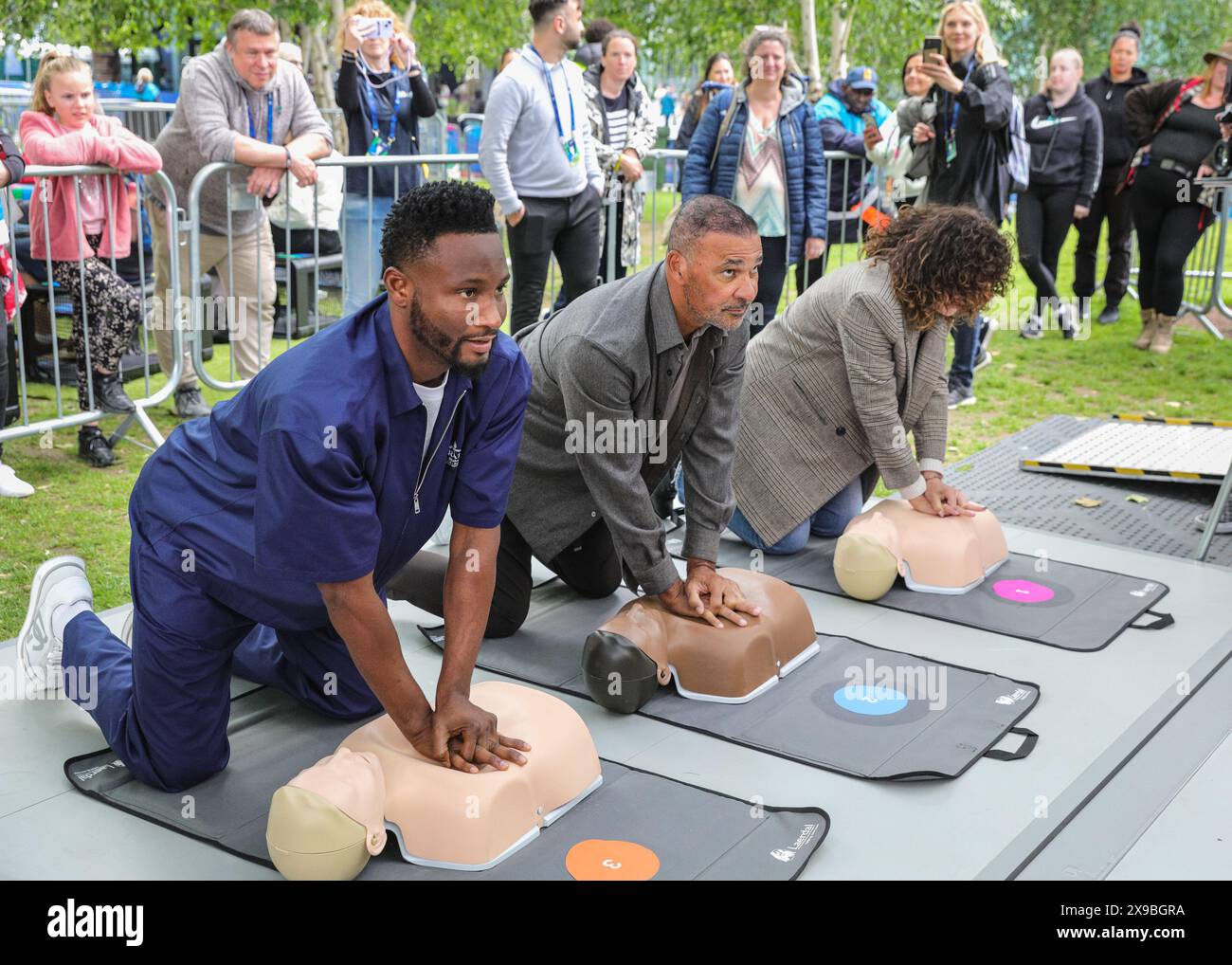Londra, Regno Unito. 30 maggio 2024. La leggenda del calcio olandese Ruud Gullit e l'altro vincitore della UEFA Champions League Mikel John Obi (noto anche come John Obi Mikel) eseguono la RCP su un manichino allo stand della campagna CPR UEFA "Get Trainer, Save Lives" al Potters Fields Park, parte del UEFA Champions Festival gratuito per tifosi e visitatori. Crediti: Imageplotter/Alamy Live News Foto Stock
