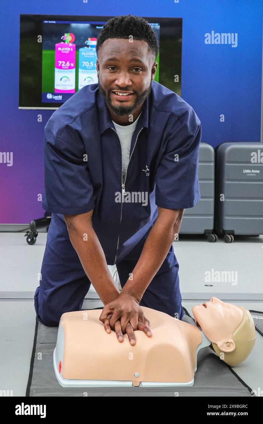 Londra, Regno Unito. 30 maggio 2024. Mikel John Obi (noto anche come John Obi Mikel), ex giocatore del Chelsea e vincitore della UEFA Champions League. La leggenda del calcio olandese Ruud Gullit e l'altro vincitore della UEFA Champions League Mikel John Obi eseguono CPR su un manichino allo stand della campagna UEFA CPR "Get Trainer, Save Lives" al Potters Fields Park, parte del UEFA Champions Festival gratuito per tifosi e visitatori. Crediti: Imageplotter/Alamy Live News Foto Stock