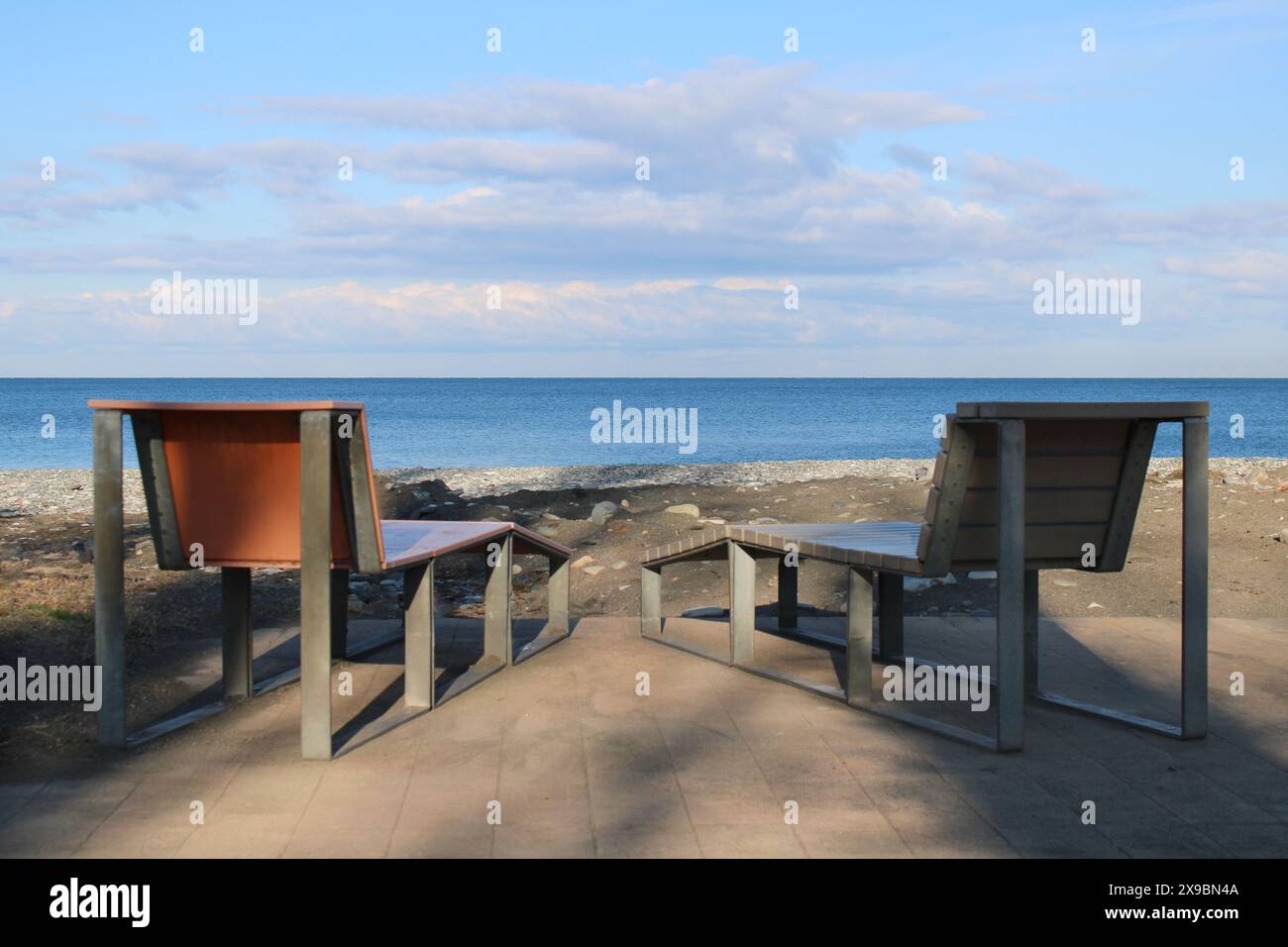 Due lettini prendisole sorgono sulla spiaggia sabbiosa del Mar Nero in una soleggiata mattinata d'estate. Atmosfera di vacanza, preparazione per le vacanze in famiglia Foto Stock
