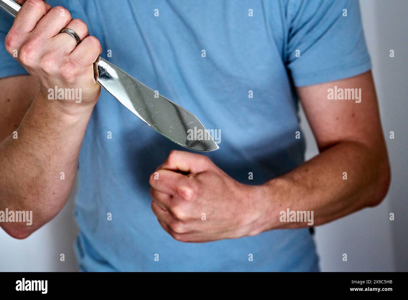 30 maggio 2024: Immagine simbolica della violenza domestica. Un uomo arrabbiato tiene in mano un coltello e stringe il pugno *** Symbolbild häusliche Gewalt. Ein wütender Mann hält ein Messer in der Hand und ballt die Faust zusammen Foto Stock