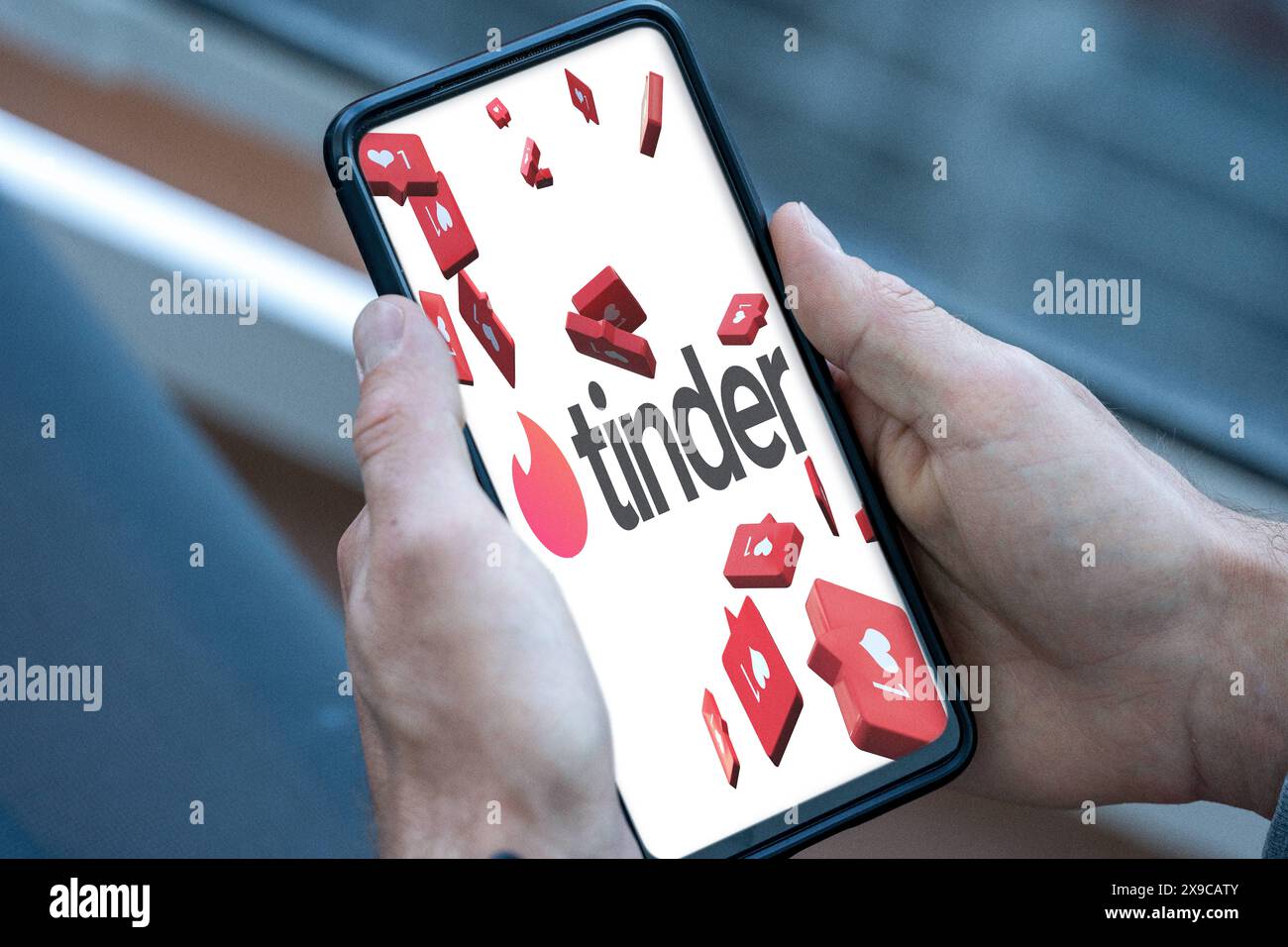 30 maggio 2024: Telefono cellulare o smartphone nelle mani di una persona che apre l'app di appuntamenti Tinder su Internet per cercare relazioni online o una data e appare il logo. FOTOMONTAGGIO *** maneggevole Smartphone in der hand einer person, welche mobil im Internet Die Dating-App Tinder öffnet, um nach Beziehungen im Internet bzw. Nach einem Date zu suchen und das Logo erscheint. FOTOMONTAGE Foto Stock