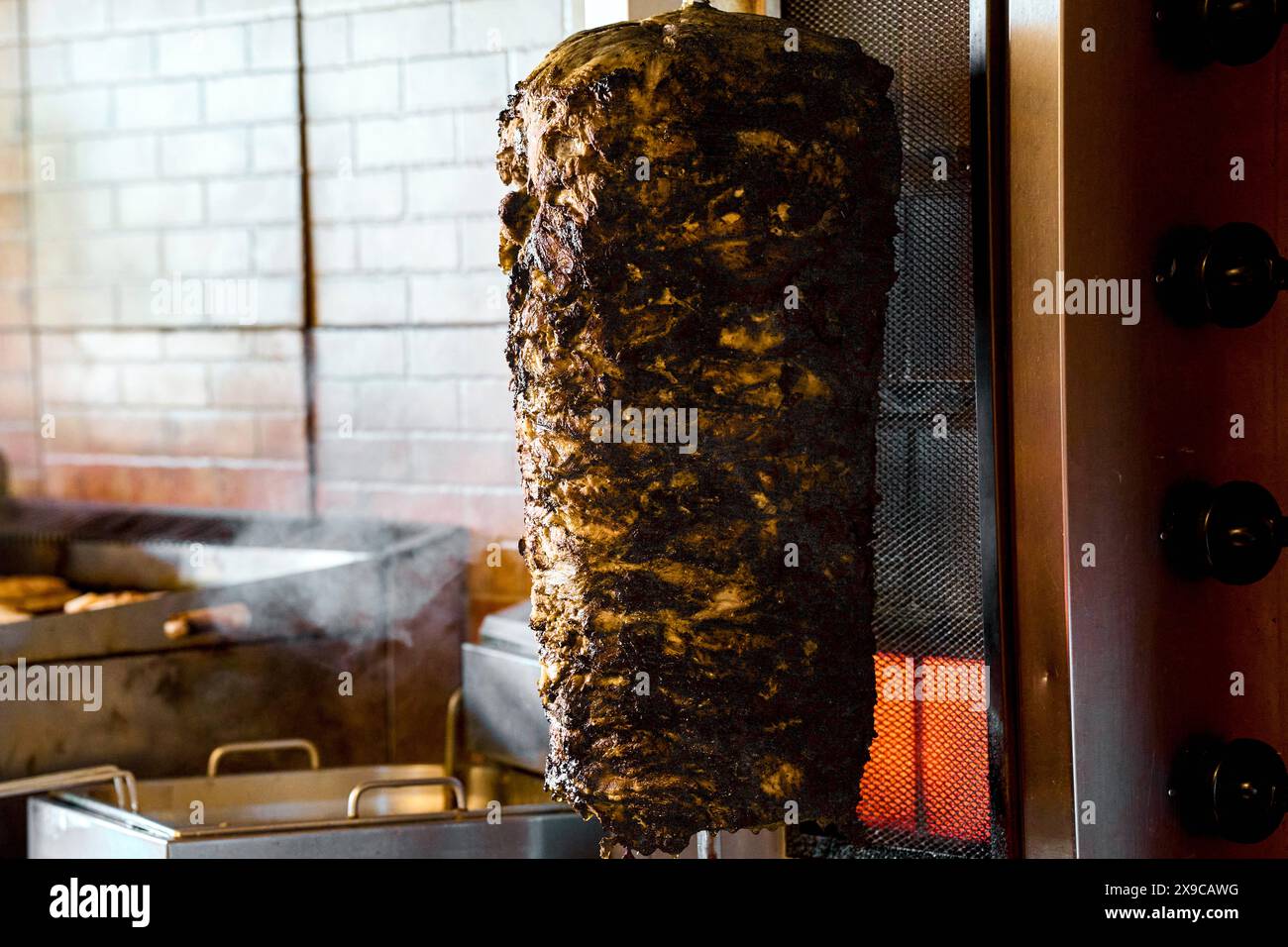 30 maggio 2024: Spiedino di kebab a rotazione o spiedino di carne di un kebab totalmente vietato e immangiabile, immagine simbolica per il cibo bruciato e la carne marcio, o carne disgustosa. FOTOMONTAGGIO *** Drehender Dönerspieß bzw. Fleischspieß eines Döner Kebab total verbannt und ungenießbar, Symbolbild für verbranntes Essen und Gammelfleisch, bzw. Ekelfleisch. FOTOMONTAGE Foto Stock